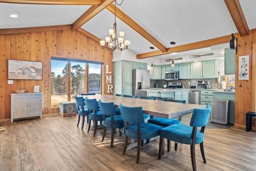 a kitchen with a large wooden table and blue chairs at Lodge at Mount Rushmore in Keystone