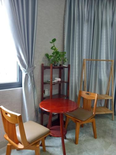 a table and two chairs and a table with a plant at Trump Homestay in Ấp Lò Gốm