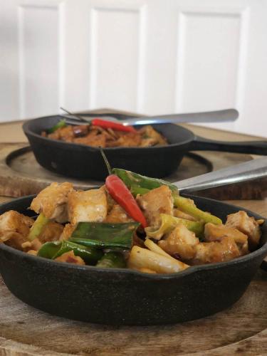 two black dishes of food on a table at Casa De Española Hotel and Resort in Aritao