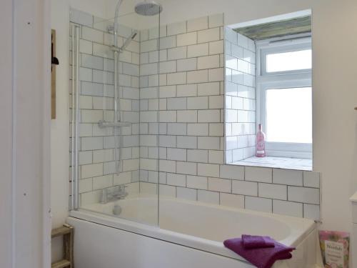 a bathroom with a tub and a window at Pipistrelle Cottage - Uk34447 in Mathry