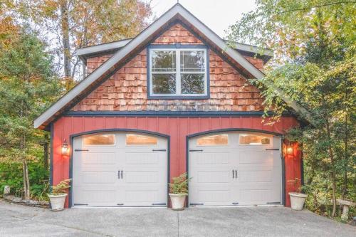a red garage with two white garage doors at Colibri Cabin on a peaceful lake, with a hot tub! in East Bernstadt