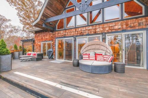 a patio with a couch on a wooden deck at Colibri Cabin on a peaceful lake, with a hot tub! in East Bernstadt