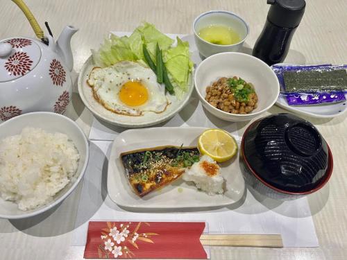 a table topped with plates of food and bowls of rice at Yamamoto Ryokan in Fukuoka