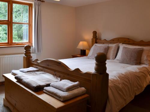 a bedroom with a wooden bed with towels on it at Elesa Cottage in Elsing