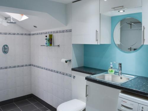 een badkamer met een wastafel en een spiegel bij Elesa Cottage in Elsing