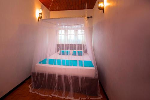 a bed with a canopy in a room at Sidangana House Ahangama in Ahangama