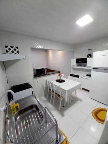 eine weiße Küche mit einem weißen Tisch und einer weißen Theke in der Unterkunft Apartamento Aconchegante in Boa Vista
