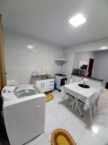 eine Küche mit einer Waschmaschine und einem Tisch in der Unterkunft Apartamento Aconchegante in Boa Vista