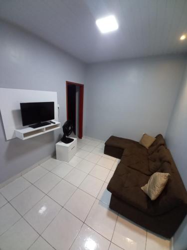 ein Wohnzimmer mit einem Sofa und einem Flachbild-TV in der Unterkunft Apartamento Aconchegante in Boa Vista