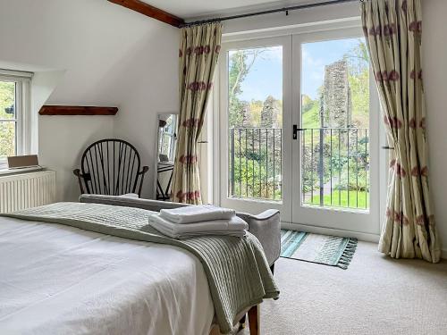 a bedroom with a bed and a large window at Priory Stile in Haverfordwest