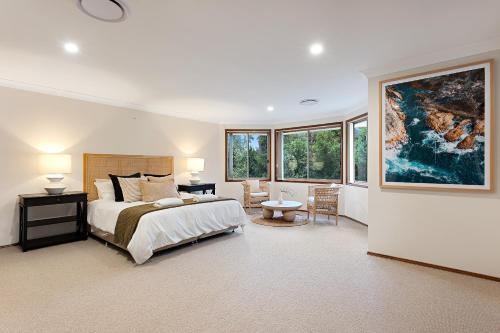 1 dormitorio con 1 cama, mesa y sillas en Shell Cove Coastal Haven en Shellharbour