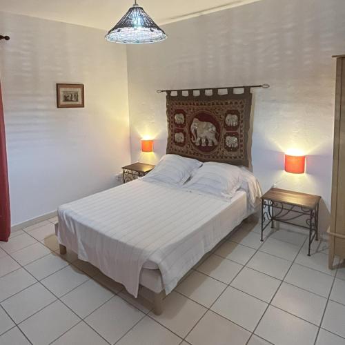 a bedroom with a large bed with two night stands at RUBIS-Villa le colibri in Dubédou