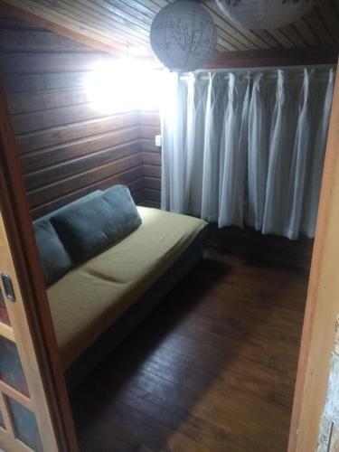 a small bed in a room with a window at Apartamento do lago in Gramado