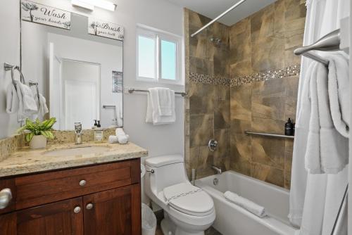 a bathroom with a toilet and a tub and a sink at Ocean View Paradise w Private Patio & Spa in San Diego