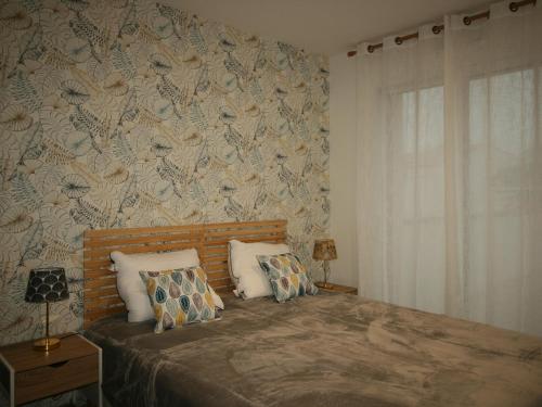 une chambre avec un lit avec un papier peint fleuri dans l'établissement Villa Contemporaine Près de la Plage avec Jardin, Terrasse et Wifi - FR-1-22-359, à La Tranche-sur-Mer