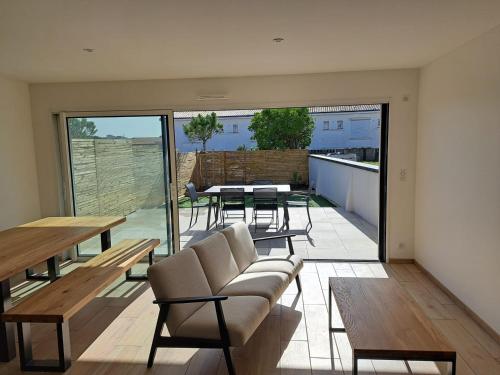 un salon avec un canapé et une table dans l'établissement Villa Contemporaine Près de la Plage avec Jardin, Terrasse et Wifi - FR-1-22-359, à La Tranche-sur-Mer