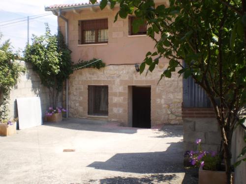 ein großes Steingebäude mit einer Tür im Innenhof in der Unterkunft Los Olmos Holiday Home in Fuentidueña