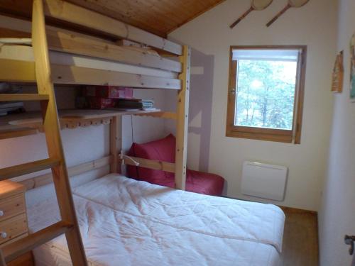 une chambre avec deux lits superposés et une fenêtre dans l'établissement Appartement 2 pièces avec mezzanine, balcon et parking près centre Samoëns - FR-1-629-135, à Samoëns