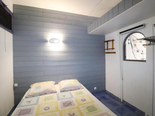 une chambre avec un lit avec un mur bleu dans l'établissement Appartement 2 pièces, 6 pers, proche plage, animaux acceptés, parking - FR-1-307-247, au Grau-du-Roi