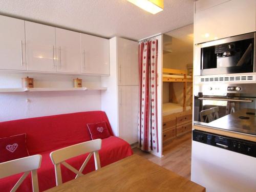 - une petite cuisine avec un canapé rouge dans une chambre dans l'établissement Appartement cosy 4/5 pers. à l'Alpe d'Huez, balcon, prox. commerces & remontées, casier à skis - FR-1-405-341, à Huez