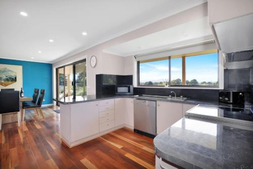 a kitchen with white cabinets and a large window at Bella Vista - Mansfield - Sleeps 8 in Mansfield