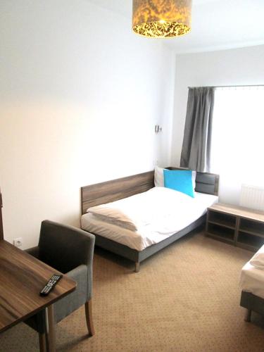a bedroom with a bed and a table and a window at Hotel Serby in Głogów