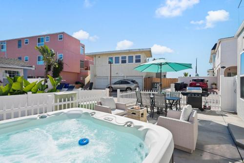 a hot tub on a patio with a table and chairs at Mission Paradise - Spa, Pet Friendly, Steps2Sand in San Diego