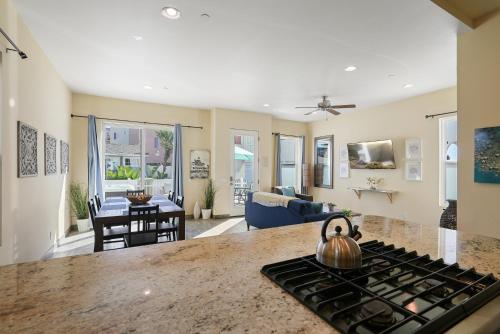a kitchen and living room with a stove at Mission Paradise - Spa, Pet Friendly, Steps2Sand in San Diego