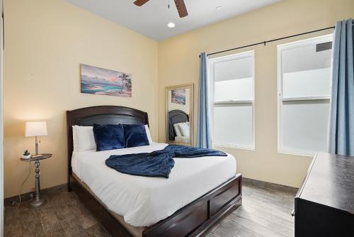 a bedroom with a bed and two windows at Mission Paradise - Spa, Pet Friendly, Steps2Sand in San Diego
