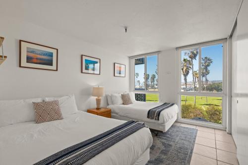 um quarto com 2 camas e uma janela em Belmont Modern - Ocean View, Pet Friendly, Patio em San Diego