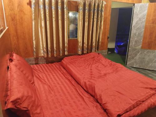 Bett mit einer roten Bettdecke in einem Zimmer in der Unterkunft Hải Đăng Homestay in Loung Co