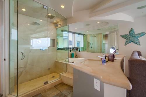 a bathroom with a glass shower and a sink at Stunning Oceanfront Boardwalk Condo - Spa, Steps2Beach, Parking & Fast Wifi! in San Diego