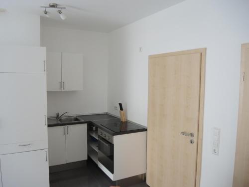 a small kitchen with a stove and a door at Wohnwerk41 in Schwäbisch Hall