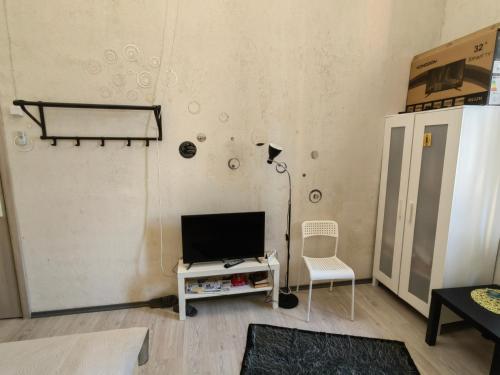 a living room with a tv and a chair at Apartment in city center in Daugavpils