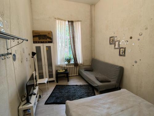 ein Wohnzimmer mit einem Sofa und einem TV in der Unterkunft Apartment in city center in Daugavpils