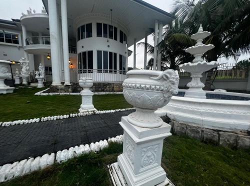 a group of white vases in front of a building at The Peacock Mansion in Kumasi