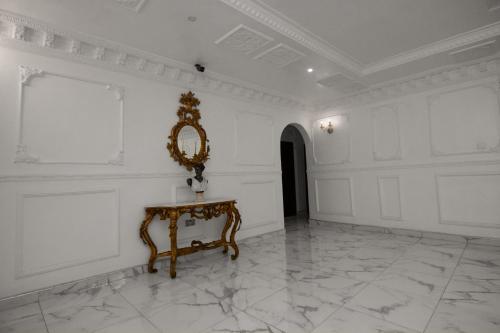a white room with a mirror and a table at The Peacock Mansion in Kumasi