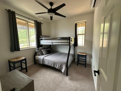 a bedroom with a bunk bed and a ceiling fan at NEW HOME in Private Community with Ocean/Mountain Views. 5 Min. Drive to Beach in Waianae