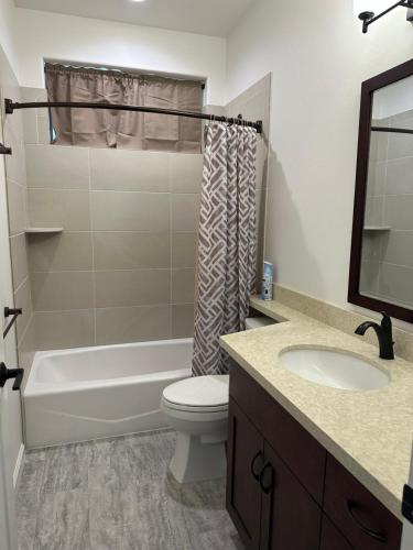 a bathroom with a tub and a toilet and a sink at NEW HOME in Private Community with Ocean/Mountain Views. 5 Min. Drive to Beach in Waianae