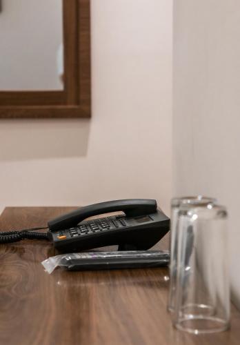 a black phone sitting on top of a wooden table at Hotel Arthemisa in Dolores Hidalgo