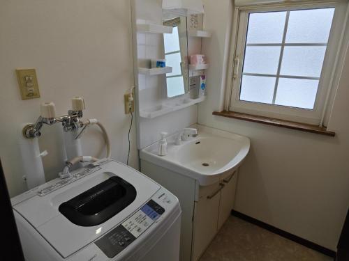 a bathroom with a sink and a washing machine at Biei Snow House - Vacation STAY 14827 in Biei