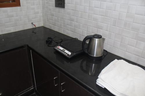 a coffee pot on a counter in a kitchen at Regency apartment in Mysore