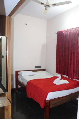 a bedroom with two beds and a red curtain at Regency apartment in Mysore