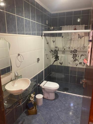 een badkamer met een wastafel, een toilet en een douche bij Recanto das Maritacas in Votorantim