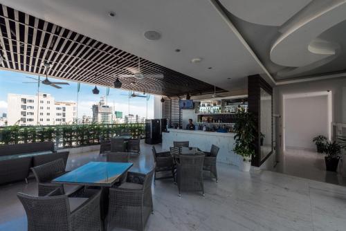 a restaurant with a bar and tables and chairs at Naki Suites @ Silvertown in Phnom Penh