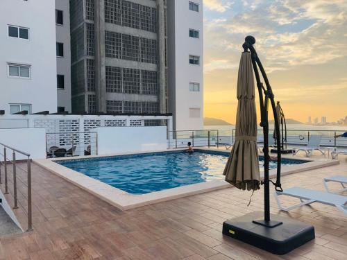 a pool on the roof of a building with an umbrella at Torre Alba 103 in Mazatlán