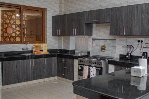 a kitchen with wooden cabinets and black counter tops at Destiny homes in Mombasa