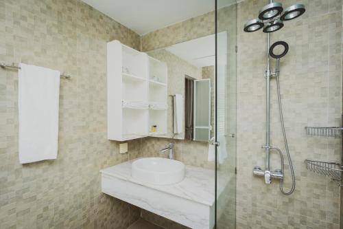 a bathroom with a sink and a shower at Naki Suites @ Silvertown in Phnom Penh