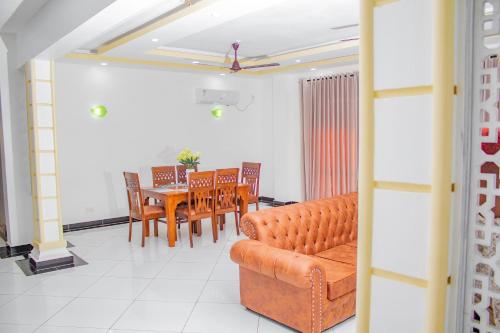 a living room with a couch and a table and chairs at Destiny homes in Mombasa