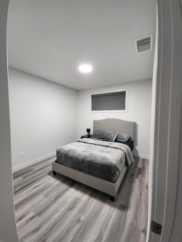 - une chambre blanche avec un lit dans l'établissement Home Away From Home, à Edmonton